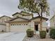 Charming two-story home featuring a well-maintained front yard with mature tree and an attached two-car garage at 209 Copper Pine Ave, North Las Vegas, NV 89031