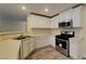 Well-lit kitchen with stainless steel appliances, white cabinets, and modern countertops at 209 Copper Pine Ave, North Las Vegas, NV 89031