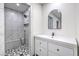 Modern bathroom features stylish white tiling, shower, and arched mirror offering spa-like experience at 210 E Longacres Dr, Henderson, NV 89015