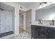 Modern bathroom featuring double sinks, tiled floors, and a glass shower at 210 E Longacres Dr, Henderson, NV 89015