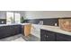 Modern laundry room featuring stylish black cabinetry, white quartz countertops, and unique geometric backsplash at 210 E Longacres Dr, Henderson, NV 89015