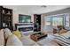 Cozy living room features a modern fireplace, built-in bookshelves, and a large window, creating a relaxing atmosphere at 210 E Longacres Dr, Henderson, NV 89015