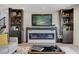 Elegant living room featuring a cozy fireplace, built-in shelving, and a modern design, creating a welcoming space at 210 E Longacres Dr, Henderson, NV 89015