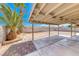 Large backyard patio featuring a covered area, brick pavers, landscaping, and ample space for outdoor activities at 2103 Falcon Crest Ave, North Las Vegas, NV 89031