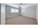 Spacious bedroom featuring a ceiling fan, window, and neutral carpeting at 2103 Falcon Crest Ave, North Las Vegas, NV 89031