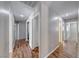 Long hallway featuring wood flooring, neutral walls, leading to various rooms in the home at 2103 Falcon Crest Ave, North Las Vegas, NV 89031