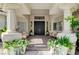 Inviting home entrance featuring a covered porch with elegant columns, seating and lovely potted plants at 2345 Villandry Ct, Henderson, NV 89074