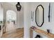 Elegant hallway with hardwood floors, arched doorways, decorative mirrors, and stylish light fixtures at 2345 Villandry Ct, Henderson, NV 89074