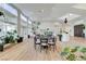 Open floor plan with a dining area, and a living room featuring large windows providing natural light and hardwood floors at 2345 Villandry Ct, Henderson, NV 89074