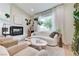 A cozy living room features a fireplace, white sofa, two armchairs, and natural light at 2345 Villandry Ct, Henderson, NV 89074