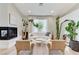 A cozy living room boasts a fireplace, white sofa, two armchairs, a mirror, and natural light at 2345 Villandry Ct, Henderson, NV 89074