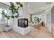 A cozy living room boasts a fireplace, white sofa, two armchairs, a mirror, and natural light at 2345 Villandry Ct, Henderson, NV 89074