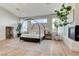 Spacious main bedroom featuring a canopy bed, fireplace, light wood floors, and modern lighting at 2345 Villandry Ct, Henderson, NV 89074