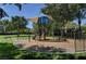 Community playground with shade cover, surrounded by green grass and mature trees creating a welcoming outdoor space at 2345 Villandry Ct, Henderson, NV 89074