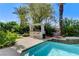 Relaxing outdoor bar area next to a refreshing pool, surrounded by lush landscaping at 2345 Villandry Ct, Henderson, NV 89074