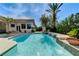 Stunning pool area boasts a waterfall feature and a seamless transition to the covered patio and outdoor living space at 2345 Villandry Ct, Henderson, NV 89074