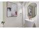 Modern powder room featuring a pedestal sink, an elegant mirror, art, and contemporary fixtures and finishes at 2345 Villandry Ct, Henderson, NV 89074
