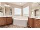 Bright bathroom with a soaking tub, dual vanities and large mirrors at 2521 Cattrack Ave, North Las Vegas, NV 89081