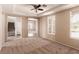 Cozy carpeted bedroom featuring bright windows and a tray ceiling with a ceiling fan at 2521 Cattrack Ave, North Las Vegas, NV 89081