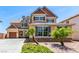 Charming two-story home featuring tan siding, gray shutters, and well-maintained landscaping at 2521 Cattrack Ave, North Las Vegas, NV 89081