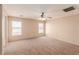 Bright main bedroom with carpet, ceiling fan, and natural light from large windows at 2521 Cattrack Ave, North Las Vegas, NV 89081