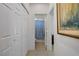 Hallway with white doors, tan tile floors, and a bathroom with a blue shower curtain in the background at 2851 Glistening Grove Ave, Henderson, NV 89052