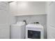 Compact laundry room featuring a side-by-side washer and dryer with a shelf for storage at 2851 Glistening Grove Ave, Henderson, NV 89052