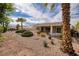 Expansive backyard with mature palm trees, desert landscaping, a covered patio, and comfortable seating at 3071 Lake Barkley Rd, Henderson, NV 89052