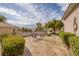 Charming courtyard featuring decorative metal lawn furniture, mature shade trees, and desert landscaping at 3071 Lake Barkley Rd, Henderson, NV 89052