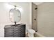 Modern bathroom with a sleek vanity, oval mirror, and walk-in shower with neutral tiling at 3318 N Decatur Blvd # 1107, Las Vegas, NV 89130