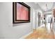 Long hallway with hardwood floors leads to living areas with large framed art decorating the walls at 360 E Desert Inn Rd # 1803, Las Vegas, NV 89109