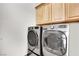 Efficient laundry room features modern stainless steel washer and dryer with overhead cabinetry at 360 E Desert Inn Rd # 1803, Las Vegas, NV 89109