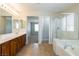 Bathroom with double vanity sinks, glass shower, and large tub at 3615 Dutchmans Vine Ct, North Las Vegas, NV 89081
