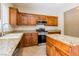 Modern kitchen featuring granite countertops, wood cabinets, and stainless steel appliances at 3615 Dutchmans Vine Ct, North Las Vegas, NV 89081