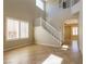 Bright living room with high ceilings, tiled floors, and a staircase with white railings at 3615 Dutchmans Vine Ct, North Las Vegas, NV 89081