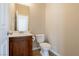 This powder room features a single sink with dark wood cabinets and a standard toilet at 3615 Dutchmans Vine Ct, North Las Vegas, NV 89081