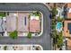 An aerial view showcasing a well-maintained home with a red-tiled roof, complemented by a lush green backyard and mature trees at 3954 Crystal Trip Ct, Las Vegas, NV 89129
