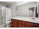 Bathroom with neutral colors featuring a shower and a toilet, with a wood vanity and white countertops at 3954 Crystal Trip Ct, Las Vegas, NV 89129