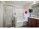 Bright bathroom featuring a frosted glass shower door, white soaking tub, and wood vanity at 3954 Crystal Trip Ct, Las Vegas, NV 89129