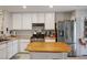 Bright kitchen features white cabinets, stainless steel appliances, and a cozy eat-in island with butcher block top at 3954 Crystal Trip Ct, Las Vegas, NV 89129