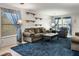 Comfortable living room with plush blue carpet, decorative shelves, and ample natural light at 3954 Crystal Trip Ct, Las Vegas, NV 89129