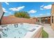Backyard featuring a hot tub, brick wall, and shaded seating area under a pergola at 4062 Vulcan St, Las Vegas, NV 89122