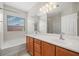 Bathroom with double sink vanity, mirror, and bath with window at 4062 Vulcan St, Las Vegas, NV 89122