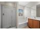 Bright bathroom with a separate tub and shower with glass doors, as well as wood cabinets at 4062 Vulcan St, Las Vegas, NV 89122