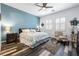 Stylishly appointed main bedroom with wood-look flooring, a ceiling fan, and a soothing accent wall at 417 Honeybrush Ave, Henderson, NV 89011