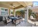 Covered patio area with a gas fire pit, seating, and a decorative lattice wall at 417 Honeybrush Ave, Henderson, NV 89011
