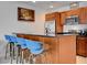 Modern kitchen features stainless steel appliances, brown cabinets and a breakfast bar with four blue chairs at 4525 Dean Martin Dr # 901, Las Vegas, NV 89103