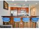 Stylish kitchen features stainless steel appliances, brown cabinets and a breakfast bar with four blue chairs at 4525 Dean Martin Dr # 901, Las Vegas, NV 89103