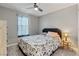 Bedroom with carpet, ceiling fan, bed with floral comforter, wooden headboard, and side table with lamp at 4559 Dover Straight St, Las Vegas, NV 89115