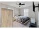 Bedroom with carpet, ceiling fan, bed with striped comforter, wooden headboard, and mounted television at 4559 Dover Straight St, Las Vegas, NV 89115
